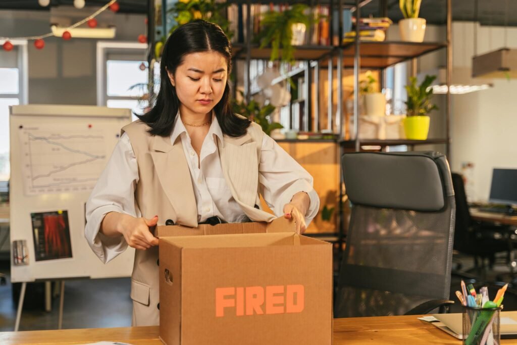 Woman in Brown Blazer Holding a Brown Cardboard Box